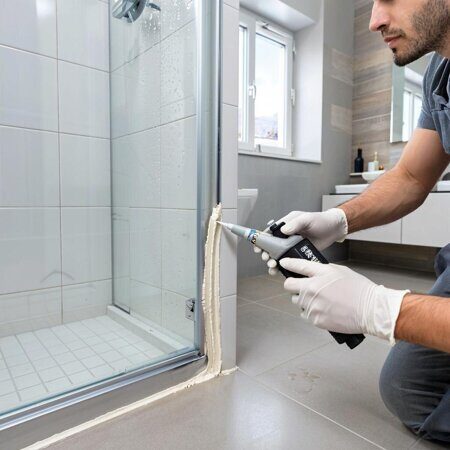изображение работник герметизирует душевую кабину